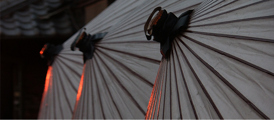 A photo from the documentary. Three
			        traditional japanese umbrellas.
